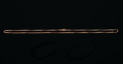 un bracelet en or et une paire de boucles d'oreilles sur fond noir