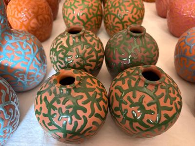 de nombreux vases de différentes couleurs posés sur une table