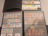 beaucoup de timbres posés sur une table, à côté d'un livre