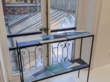 a glass shelf with a shelf on it in front of a window