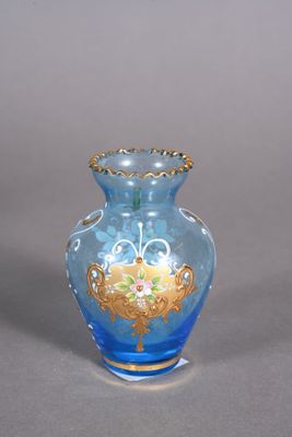 a blue glass vase with a gold decoration on it