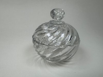 un bocal en verre transparent avec un couvercle, posé sur une surface blanche