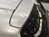 a white car parked in a garage with its hood up
