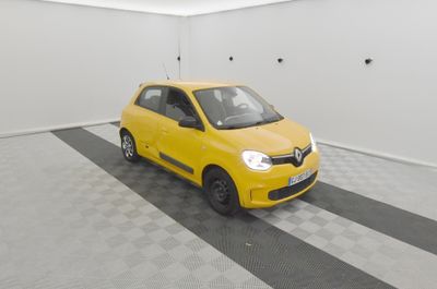 La voiture jaune est garée dans le garage, sur le sol à damier.