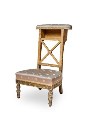une image représentant une chaise en bois dont l'assise et le dossier sont ornés de motifs