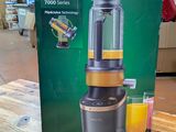 philips blender in box on wooden table with orange juice in glass