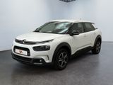 Une Citroën blanche est garée dans une grande pièce