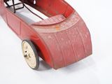 a red toy car that is sitting on a white surface