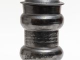 a metal container with a lid on a white surface