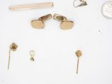 a lot of gold jewelry on a white surface