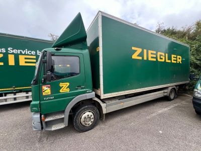 deux camions verts garés l'un à côté de l'autre sur un parking