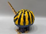 toy figurine of a yellow and black striped turtle with a stick in its mouth