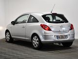the back of a silver car is parked in a room