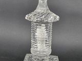 a clear glass bottle with a cross on the top