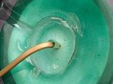 a green bowl with a wooden spoon inside of it