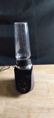 a blender sitting on a wooden table with a black background