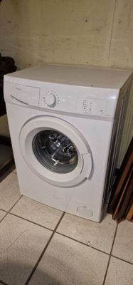 a white washing machine sitting on the floor in a room