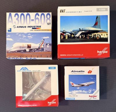 trois boîtes contenant des maquettes d'avions posées sur une table