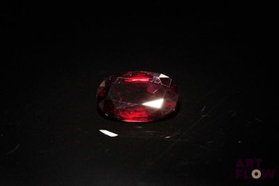 a close up of a red diamond on a black surface