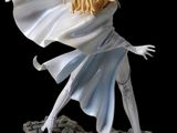 the statue of a woman with blonde hair is standing on a rock
