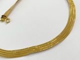 a close up of a gold necklace on a white surface