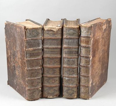 trois vieux livres empilés les uns sur les autres sur une table