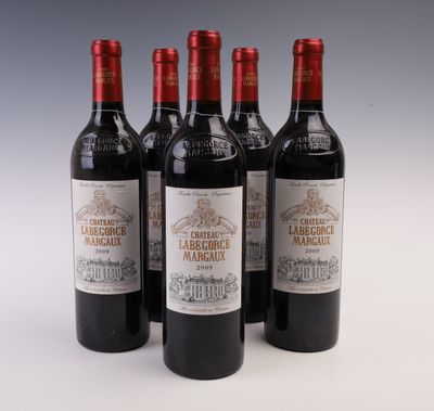quatre bouteilles de vin sont alignées sur une surface blanche