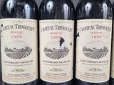 three bottles of red wine are lined up on a table