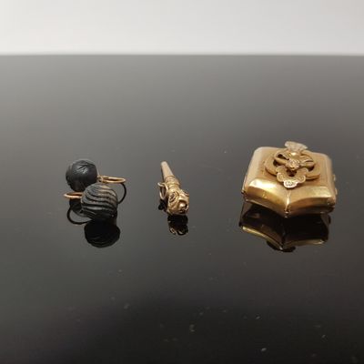 three pieces of gold and silver jewelry on a black surface