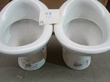 two white toilets sitting next to each other on the floor