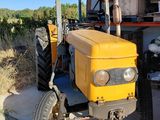 a yellow tractor that is parked in front of a building