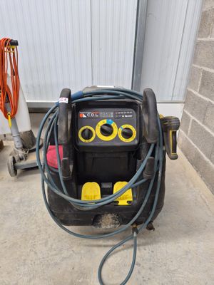 a small air compressor on the ground next to a hose