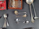 a lot of silver spoons and spoons on the table