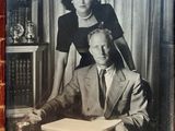 a black and white photo of a man and woman sitting at a desk