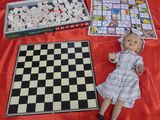a doll that is sitting next to a chess board