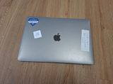 an apple laptop on a wooden table with a sticker on it