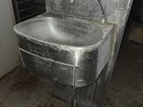 a metal sink in the middle of a dirty room