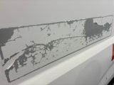 a close up of a white van with peeling paint on it