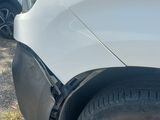 a white car that has been damaged and is sitting on the side of the road