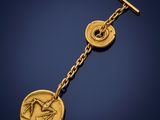 a close up of a gold plated key chain with a coin on it