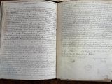 an open book with writing on it sitting on a wooden table