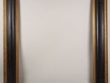 a black and gold picture frame on a white wall