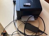 une imprimante noire posée sur une table à côté d'un ordinateur portable