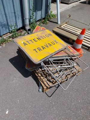 un tas de clous par terre, à côté d'un panneau de signalisation