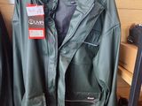 a green jacket hanging on a rack in a clothing store