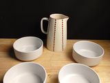 quatre bols et un pichet posés sur une table