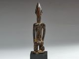 an image of a wooden statue of a person on a black base