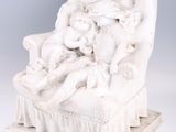 l'image d'une statue de femme assise sur une chaise