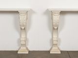 two white marble tables sitting on top of a wooden floor