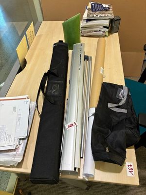 un bureau sur lequel se trouvent un ordinateur portable, un sac et d'autres objets